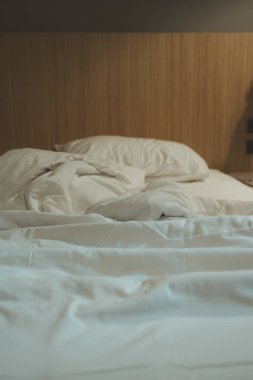Yatak odası ve battaniye yatak örtüsü beyaz kumaş manzaralı otel kırışıklıklarıyla dolu.