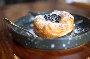 Tatlı yaban mersinli çörekleri siyah tabakta kapayın.