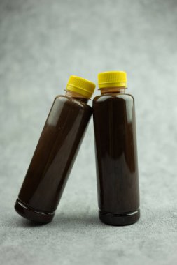 Sarı kapaklı şeffaf şişede iki şişe çikolatalı süt. Sağlıklı çikolata ve oldukça popüler bir ev al.