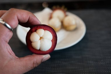 El ele tutuşarak soyulmuş mangosteen meyvesi..