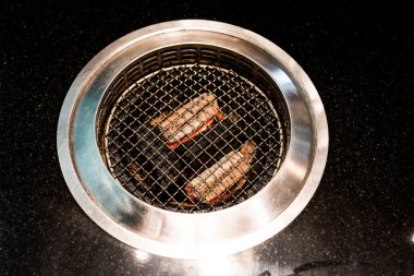 Japon usulü yakiniku yemek barbeküsü ya da barbekü için boş kömür ızgarası ve Japonya 'da bir ocakta mangal kömürü..