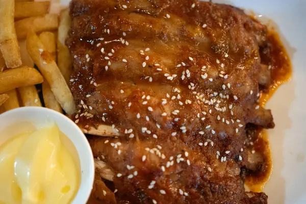 stock image Close up of pork ribs grilled with BBQ sauce served french fries and mayonnaise. Tasty snack to beer. Top view