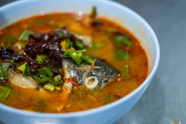 Baharatlı balık ve kafası mavi kasede Tom yum çorbası. Kapat.