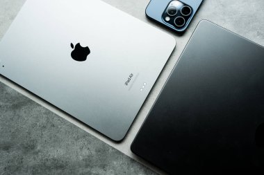 Bangkok, Tayland - 10 Ağustos 2024: Gri arka planda farklı cihaz türleri, iPhone 15 pro, iPad Air 2024 ve Macbook Pro bulunmaktadır. Elma ürünleri konsepti. Apple Inc. tarafından oluşturuldu