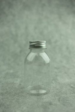 İçmek için gümüş kapaklı mini şişe boşalmış. Şeffaf şişe