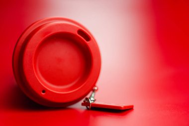 Kırmızı arka plandaki kırmızı yeniden kullanılabilir plastik kahve bardağını kapat.