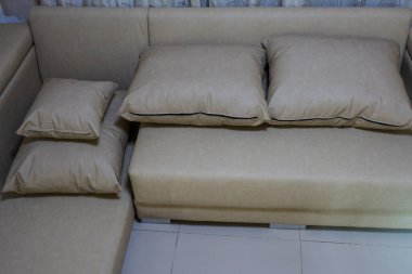 Moda dairesinin oturma odasında yastıklı büyük kremalı kanepe.