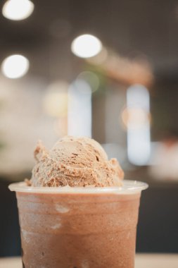 Mocha kahve frappe üzerinde serinletici bir dondurma, arka planda bulanık bir ışık var..