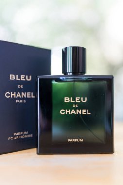 Bangkok, Tayland - 28 Ağustos 2024: Erkekler için bir şişe parfüm Bleu de Chanel, ahşap masa üzerinde Parfüm