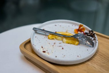 Yemekten sonra pasta lekesi ve meyve lekesi, kirli tabak, arta kalan yemek. Kapat.