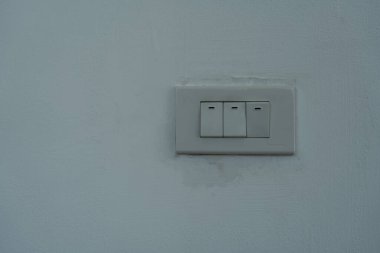 Beyaz modern ışık anahtarı beyaz beton iç duvarda.