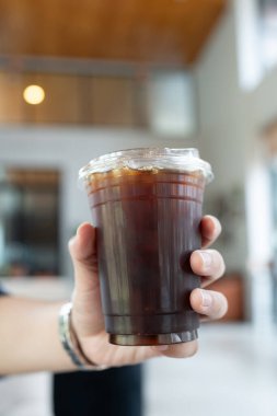 Paketlenmiş plastik fincan buzlu sade kahvenin yakın çekimi.