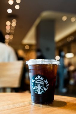 Bangkok, Tayland - 26 Eylül 2024 Starbuck kahveli Americano içeceği kafedeki ahşap masada.