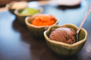 Seramik kasede çikolatalı dondurma ve dondurma arkaplanının çeşitli tatları. Çikolatalı dondurmaya seçici odaklanma