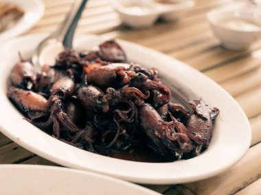 Siyah mürekkep balığı ya da sauteed mürekkep balığı mürekkebi salınana kadar pişen mürekkep balığıdır. Ortaya çıkan tat çok ayırt edicidir. İşlenmiş mürekkep balığı. Tayland deniz ürünleri tarzı..