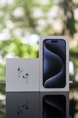Bangkok, Tayland - 16 Ekim 2024: iPhone 15 pro ve AirPods 3 nesildir doğaya karşı elma şirketinden ahşap masa üzerinde ambalaj