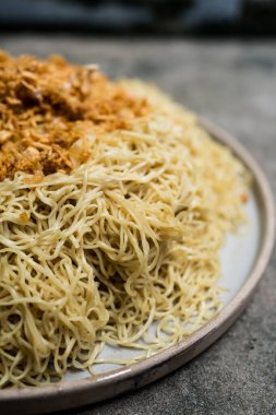 Tabağa sarımsak serpiştirilmiş sarı erişte. Yumurta sarısı erişte.