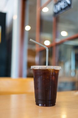 Buzlu Americano, ahşap masada şeker yok, içmeye hazır.