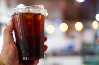 Elinde plastik bir fincan buzlu sade kahveyle fotokopi alanı var..