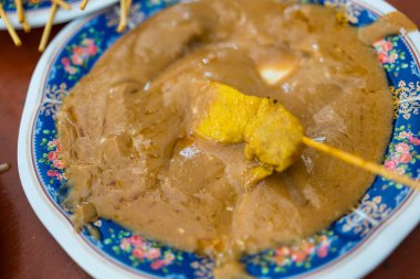 Fıstık soslu domuz eti yiyen bir el.