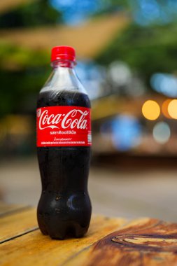 Bangkok, Tayland - 4 Kasım 2024: Coca Cola meşrubat PET plastik şişe ahşap masa üzerinde logo