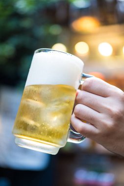 Bulanık arka planda bira içen adam.