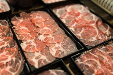 Siyah tepside servis edilen güveç için dilimlenmiş domuz eti ve biftek.