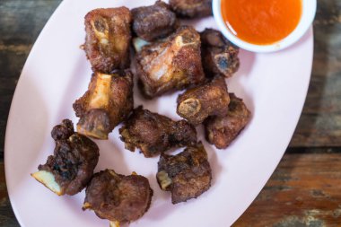 Ahşap masada acı soslu kızarmış domuz kaburgası.