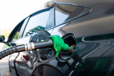 Benzin istasyonunda yakıt doldurmak, yakıt hortumunun altını çizmek.