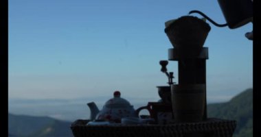 Kılavuz sabahları dağ manzaralı damlatan kahve yapar. Kahve demleme konsepti. Seyahat kavramı