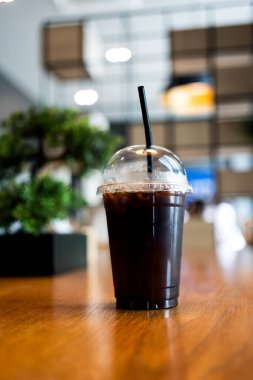 Ahşap masanın üzerinde bir fincan soğuk, siyah kahve.