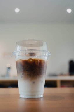 Kahve dükkanındaki ahşap masada servis edilen buzlu kahve.