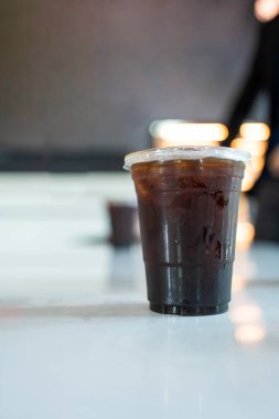 Black coffee, Americano coffee in plastic coffee cup on white table in coffee shop