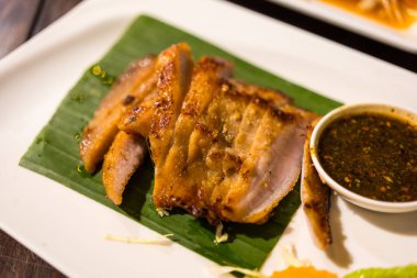 Taylandlı ızgara domuz eti ya da soslu kömürlü domuz budu Tayland 'da popüler bir aperatiftir..