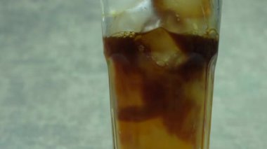 Bir bardak buzlu americano ve buz karıştırır ve taze portakal suyunu bardağa doldurur, buzlu portakal americano.