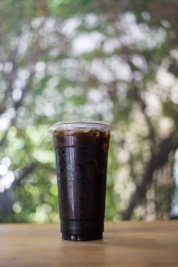 Ahşap masanın üzerinde bir fincan buzlu siyah kahve.