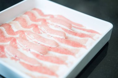 Shabu Shabu ya da Sukiyaki olarak da bilinen beyaz tepside servis edilen dilimlenmiş çiğ domuz eti..