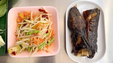 Yeşil papaya salatası ve ızgara yayın balığı. Üst görünüm