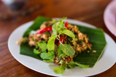 Pork Larb muz yaprağıyla servis edilir, Tayland yemeği.