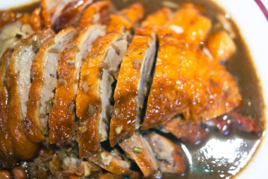 Bir tabak dilimlenmiş ördek, çıtır çıtır deri ve soslu sulu et..