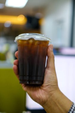 Bir fincan buzlu kahve ya da soğuk americano kahvesi, sabahları bulanık ofis arkaplanı olan soğuk bir kahve.