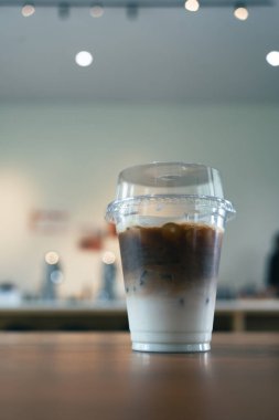Menü buzlu kahve lattesi. Ahşap masada buzlu kahve bardağı var.
