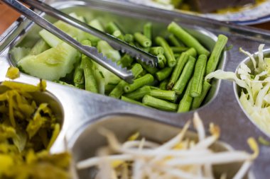 Gümüş açık büfe kuyruğu ve kesilmiş yeşil uzun fasulye dilimi.