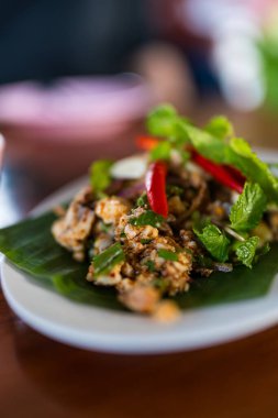 Lezzetli bir porsiyon Larb Moo, kıymalı domuz eti, taze otlar ve kırmızı soğan ve nane yapraklarıyla süslenmiş kırmızı biber. Otantik Tayland mutfağı