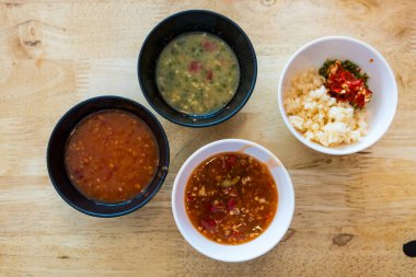 Sukiyaki sosu ve deniz ürünleri sosu kıymalı sarımsak ve siyah kasede kırmızı biber.