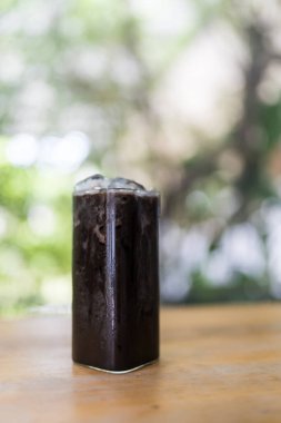 Ahşap masada buzlu, siyah bir çikolata.