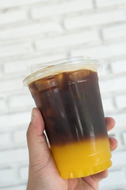 Buzlu americano sade kahve. İnsan eliyle portakal suyu karıştırılmış.