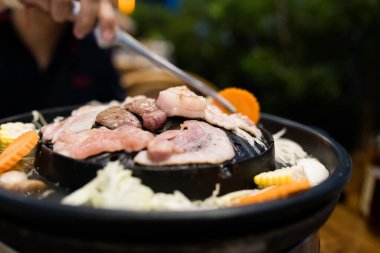 Tayland usulü barbekü. Sıcak tavada domuz eti, et ya da deniz ürünleri ızgara ile Asya 'nın popüler yiyeceğidir. Bu da sebze çorbasını tavanın etrafına da koyabilir. Tayland barbekü ızgarası Sıcak tavada domuz eti.