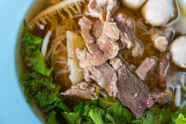 Bir kase pirinçli şehriye çorbası, etli makarna, domuz köftesi ve bağırsak. Seçici odak