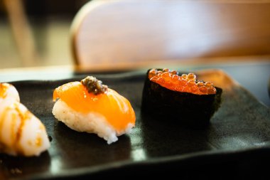 Deniz yosunu ve somon suşisine sarılı taze balık yumurtası suşisi. Japon suşisi